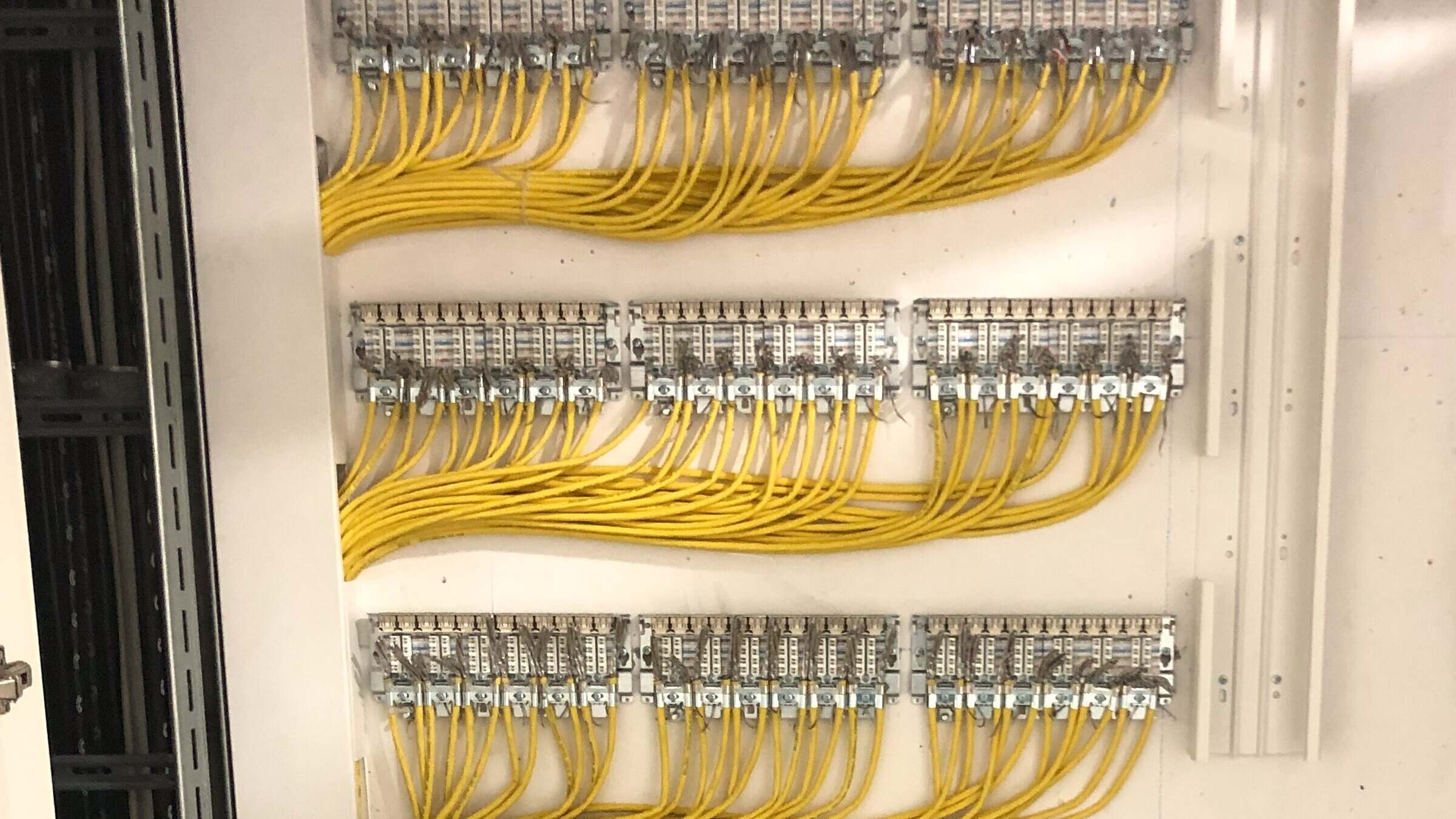 LSA-Verteiler mit drei Reihen Trennleisten und gleichmäßig aufgelegten gelben Datenleitungen