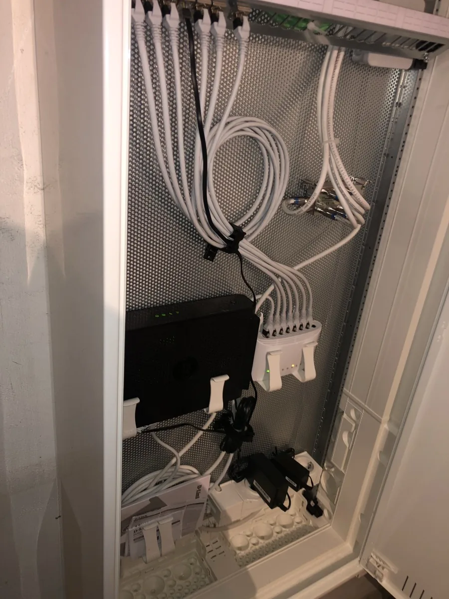 Medienverteiler mit Netzwerkleitungen und Router in einer Praxis